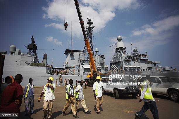 Dock workers walk in front of the frigate Karlsruhe in the Port of Djibouti on December 15, 2008 in Djibouti. The warship F212 of the German Navy...