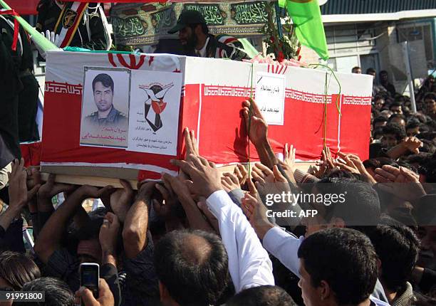 Iranians carry the coffin of an officer in Iran's elite Revolutionary Guards, killed the day before, during a mass funeral in Zahedan near the...