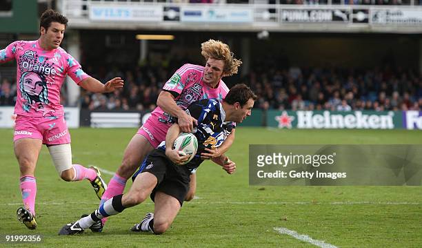 Matt Carraro of Bath is tackled by Mirco Bergamasco during the Heineken Cup match between Bath and Stade Francais at the Recreation Ground on October...