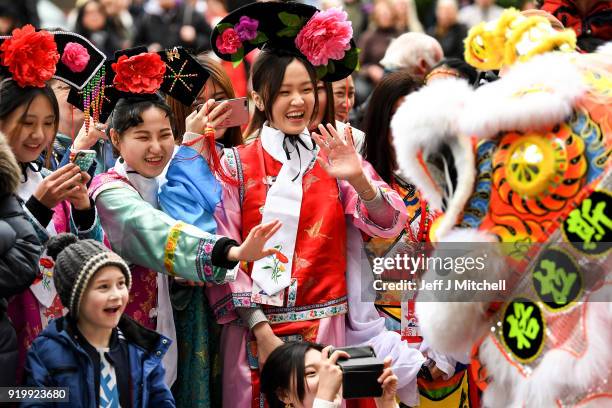 The Chinese community pose for photos in Glasgow as they celebrate during Lunar New Year celebrations for the Year of the Dog at George Square on...