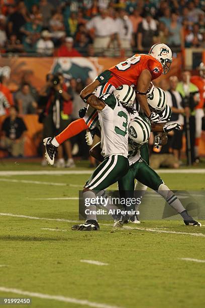 Cornerback Marquice Cole, Cornerback Drew Coleman and Wide Receiver Wallace Wright of the New York Jets stop Running back Patrick Cobbs of the Miami...