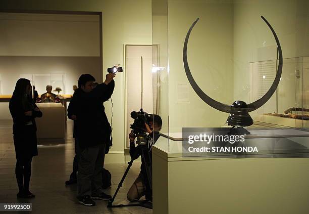 Television crew photographs Zunari-kabuto with o-nakaguri side crests, Momoyama period, 16th century, on view in the exhibition "Art of the Samurai:...