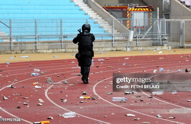 Policeman walks past rubbish on the ground following the Tunisia Ligue 1 football match derby between Esperance Sportive de Tunis and Club Africain...