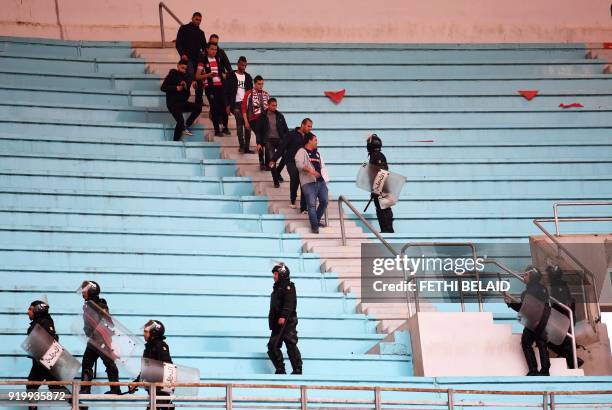 Tunisian policemen monitor as fans leave the stadium at the end of the Tunisia Ligue 1 football match derby between Esperance Sportive de Tunis and...