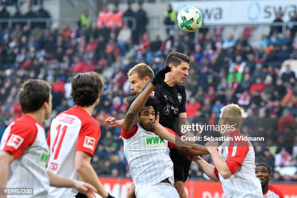Francisco da Silva Caiuby of Augsburg and Holger Badstuber and Mario Gomez of Stuttgart jump for a header during the Bundesliga match between FC...