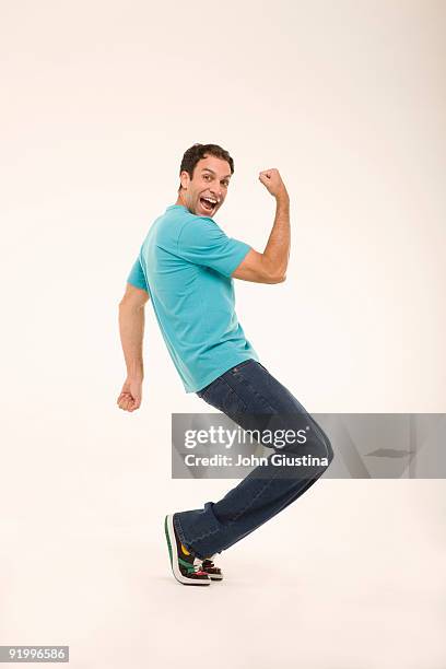 man giving fist pump, standing on toes. - homme en pied fond blanc photos et images de collection