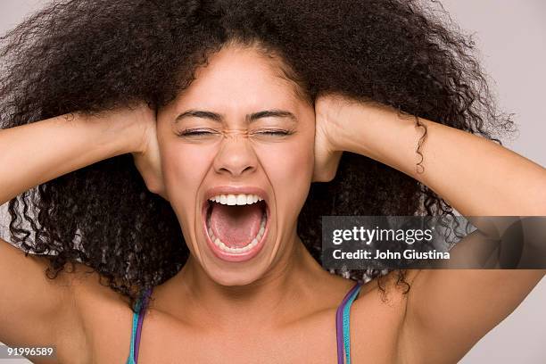 woman screaming, hands over her ears, eyes closed. - hand to ear photos et images de collection