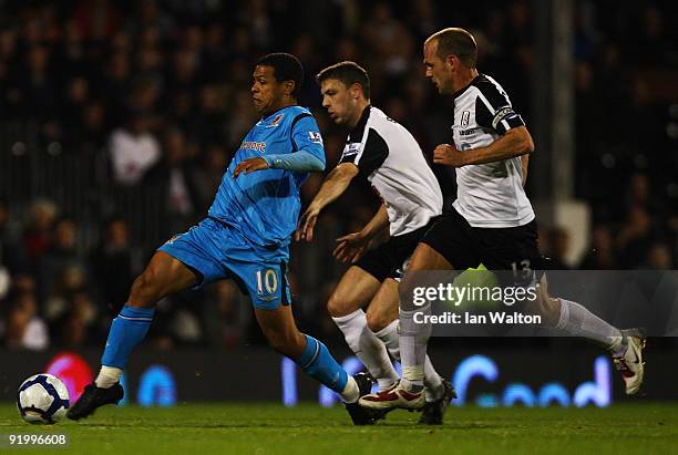 Chris Baird of Fulham tries to tackle Geovanni of Hull City during the Barclays Premier League match between Fulham and Hull City at Craven Cottage...