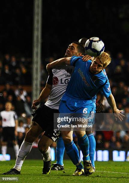 Clint Dempsey of Fulham tries to tackle Paul McShane of Hull City during the Barclays Premier League match between Fulham and Hull City at Craven...