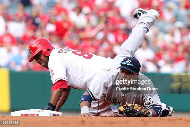 Chone Figgins of the Los Angeles Angels of Anaheim is forced out at second base by Robinson Cano of the New York Yankees as Torii Hunter grounds into...