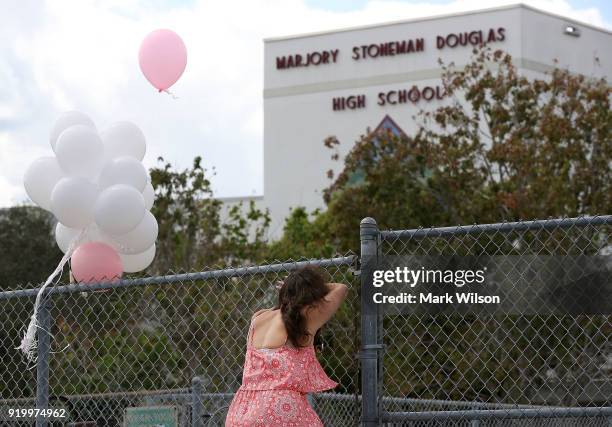 Angela Tanner, rests against the fence that surrounds the Marjory Stoneman Douglas High School, on February 18, 2018 in Parkland, Florida. Police...