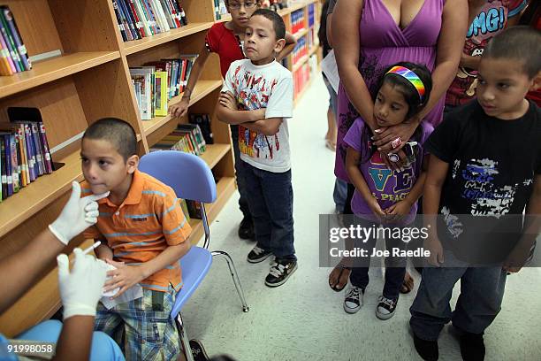 Moises Aguila Jade Jarqurn and Luis Jarqurn watch as James Jarqurn receives an H1N1 nasal flu spray vaccine from nurse Shajaira Powell-Bailey at the...