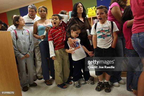 Children wait in line to receive either a H1N1 nasal flu spray vaccine or an injection at the Broadmoor Elementary school October 19, 2009 in Miami,...