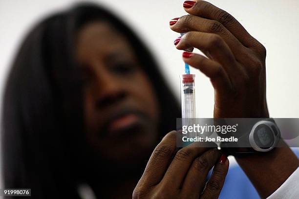 Nurse Valerie Blemur measures out a H1N1 vaccination at the Broadmoor Elementary school October 19, 2009 in Miami, Florida. The Miami-Dade County...