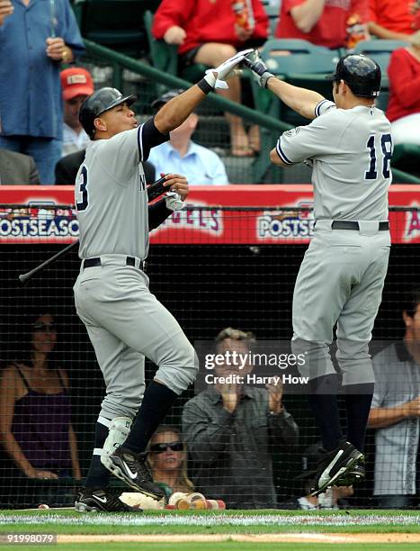 Johnny Damon of the New York Yankees celebrates with teammate Alex Rodriguez after Damon hit a home run during the fifth inning off Jered Weaver of...