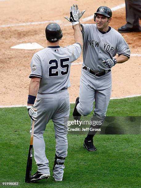 Johnny Damon of the New York Yankees celebrates with teammate Mark Teixeira after Damon hit a home run during the fifth inning off Jered Weaver of...