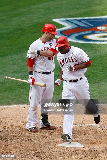 Mike Napoli of the Los Angeles Angels of Anaheim greets teammate Howie Kendrick as he crosses home plate after hitting a home run off Andy Pettitte...