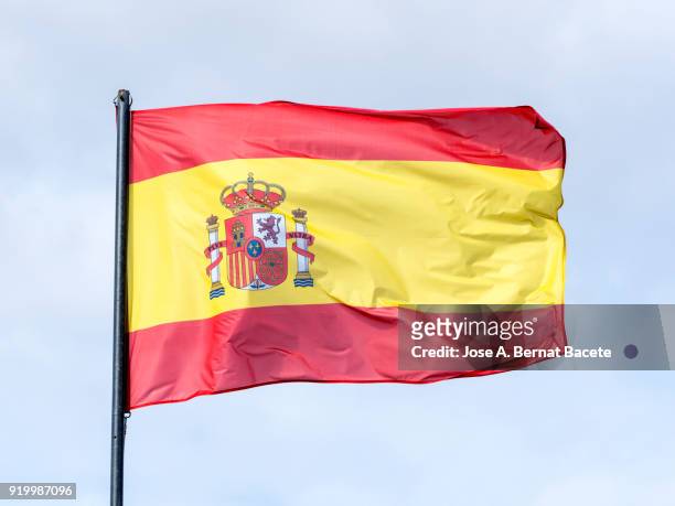 low angle view of flag spain against sky. spain - spanische flagge stock-fotos und bilder