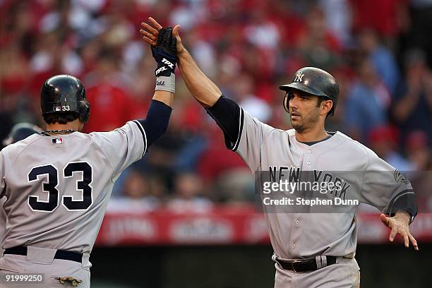 Jorge Posada of the New York Yankees celebrates with teammate Nick Swisher after Posada hit a home run during the eighth inning off Kevin Jepsen of...