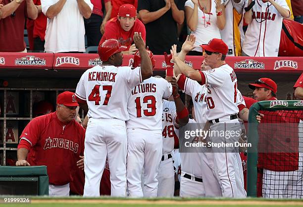 Howie Kendrick of the Los Angeles Angels of Anaheim celebrates with teammates after scoring on Maicer Izturis sacrafice fly during the seventh inning...