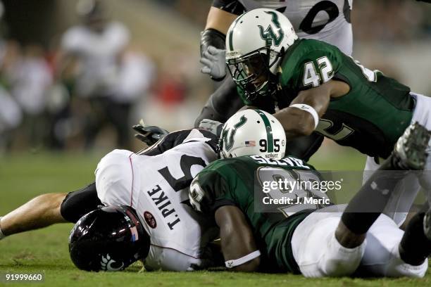 Defenders George Selvie and Kion Wilson of the South Florida Bulls sack quarterback Tony Pike of the Cincinnati Bearcats during the game at Raymond...