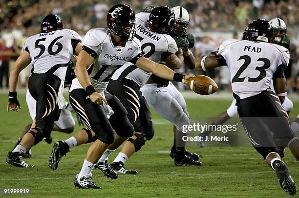 Quarterback Zach Collaros of the Cincinnati Bearcats hands the ball off against the South Florida Bulls during the game at Raymond James Stadium on...