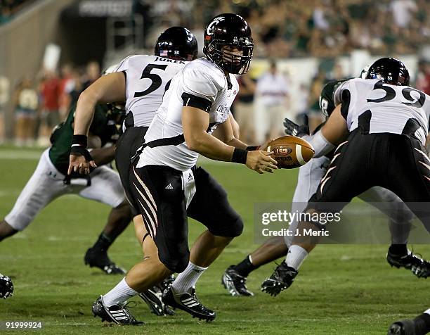 Quarterback Zach Collaros of the Cincinnati Bearcats hands the ball off against the South Florida Bulls during the game at Raymond James Stadium on...