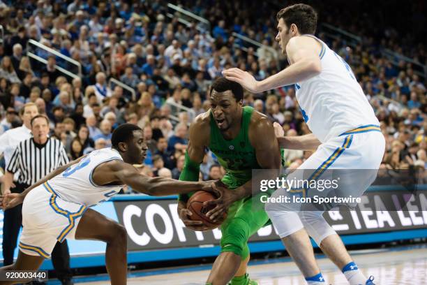 Oregon Ducks forward MiKyle McIntosh drives to the basket with UCLA Bruins guard Kris Wilkes and UCLA Bruins forward Gyorgy Goloman defending during...