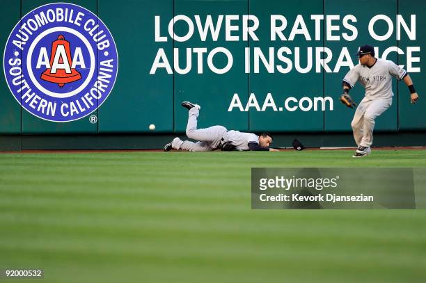 Jerry Hairston Jr. #17 of the New York Yankees crashes into the wall attempting to catch Jeff Mathis of the Los Angeles Angels of Anaheim walk off...