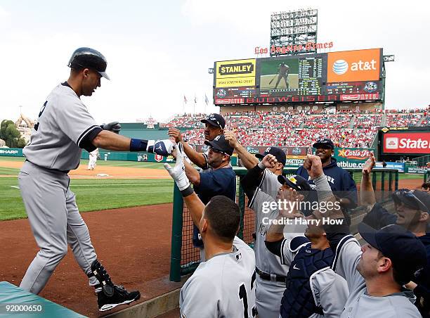 Derek Jeter of the New York Yankees celebrates with teammate Alex Rodriguez after hitting a home run during the first inning off Jered Weaver in Game...