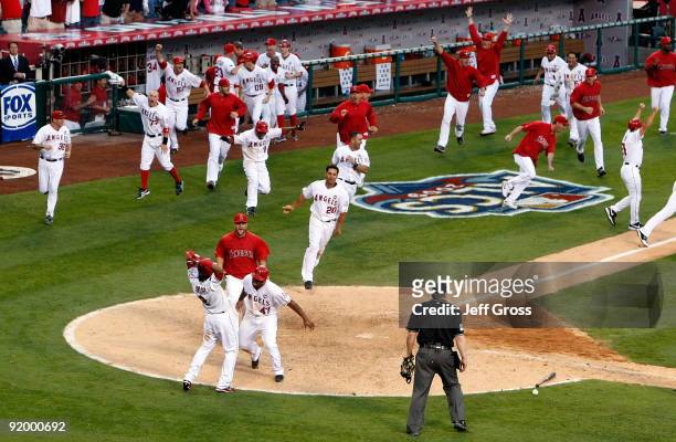 Howie Kendrick of the Los Angeles Angels of Anaheim celebrates with teammate Erick Aybar after sliding home off of Jeff Mathis walk off double in...