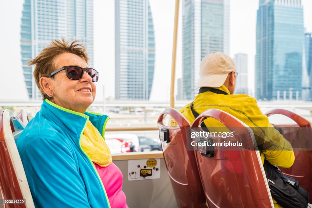 Diverse aktive Senioren - Stadtrundfahrt an windigen Tag im offenen bus