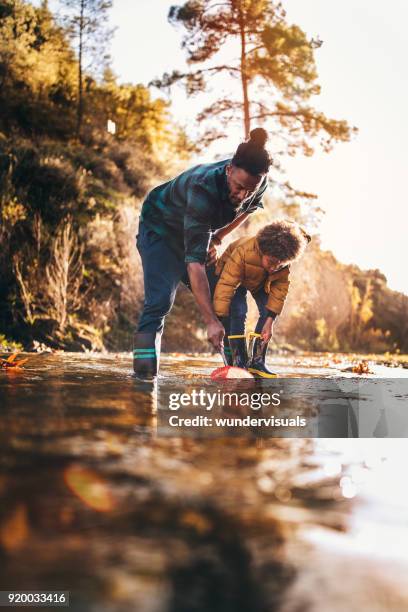 vater und sohn angeln im bergbach mit fischernetz - kids at river stock-fotos und bilder