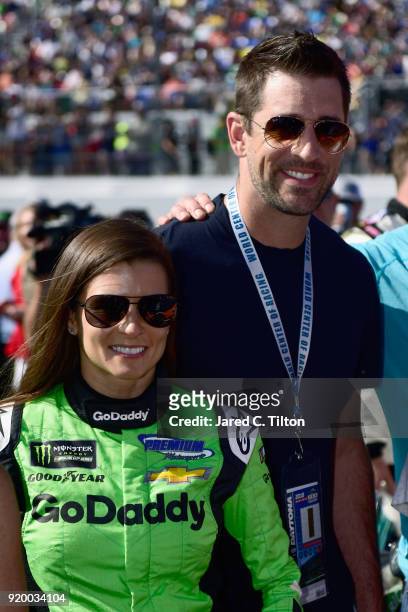 Danica Patrick, driver of the GoDaddy Chevrolet, stands with Aaron Rodgers, quarterback for the Green Bay Packers, on the grid prior to the Monster...