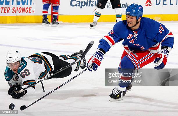 Sean Avery of the New York Rangers reaches for the puck against Jason Demers of the San Jose Sharks on October 19, 2009 at Madison Square Garden in...