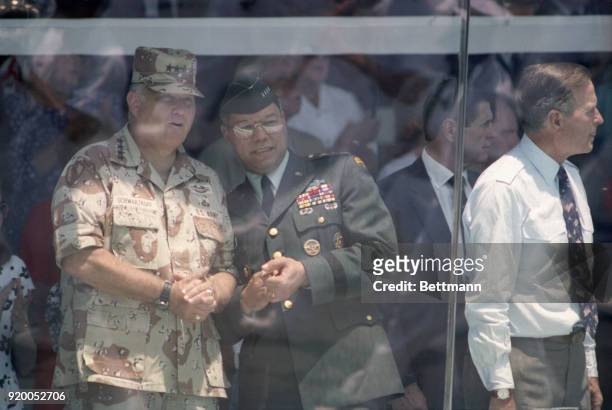 General Norman Schwarzkopf and Joint Chiefs of Staff Chairman General Colin Powell watch the Desert Storm victory parade from the reviewing stand.