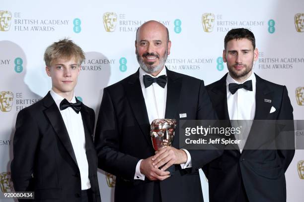Mark Bridges , winner of the Best Costume Design award for 'Phantom Thread', poses with presenters Tom Taylor and Edward Holcroft in the press room...
