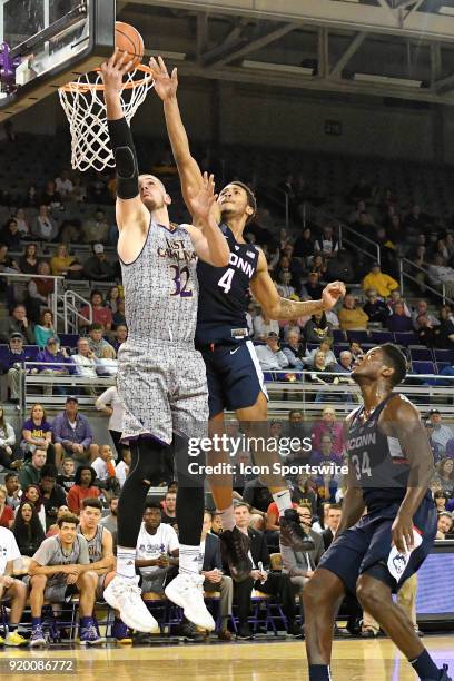 East Carolina Pirates forward Dimitri Spasojevic uses his left hand to avoid Connecticut Huskies guard Jalen Adams during a game between the ECU...