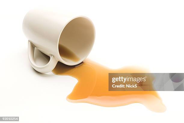 mug knocked over with spilt coffee on white background - spilled drink stock pictures, royalty-free photos & images