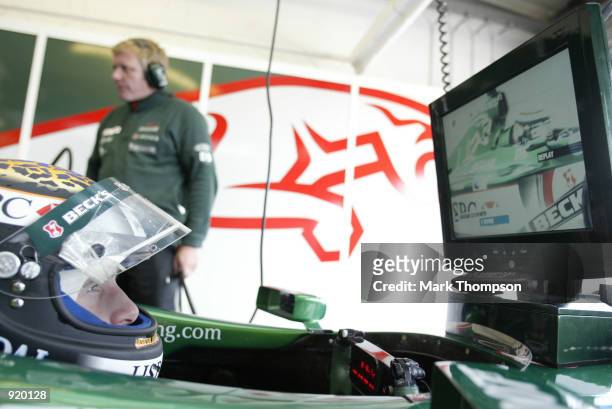 Eddie Irvine of Northern Ireland and Jaguar watches his self on the monitor during first practice for the British Grand Prix at Silverstone on July...