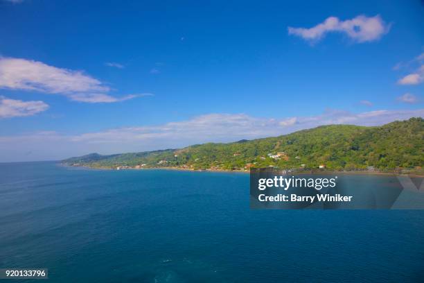 blue caribbean water and green hillside of roatan, honduras - bay islands stock pictures, royalty-free photos & images