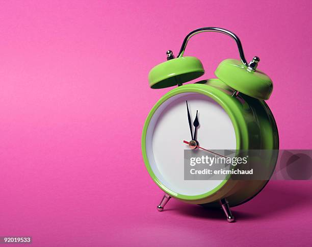 classic green alarm clock on vibrant pink background - midday stock pictures, royalty-free photos & images