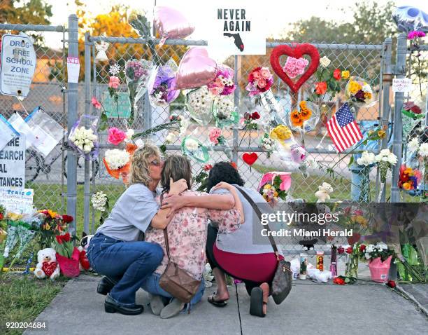 Shari Unger kisses Melissa Goldsmith as Giulianna Cerbono lights candles at a memorial at Marjory Stoneman Douglas High School on Sunday, February...