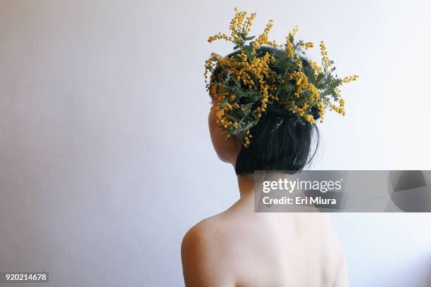 a woman wearing a fancy yellow hat made of flowers - acacia flowers stock pictures, royalty-free photos & images