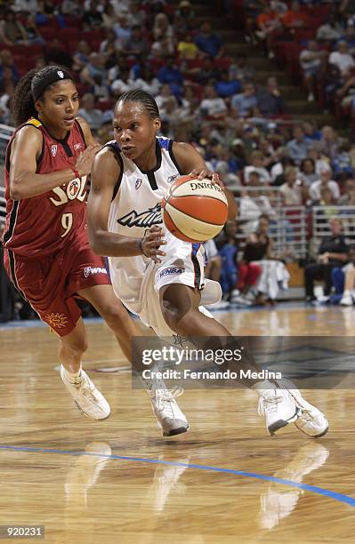 Elaine Powell of the Orlando Miracle drives past Claudia Neves of the Miami Sol in the game on June 15, 2002 at TD Waterhouse Centre in Orlando,...