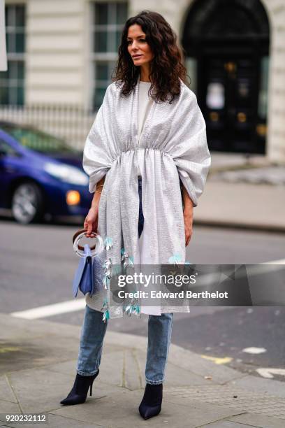 Hedvig Opshaug wears a white dress, blue jeans, black shoes, a blue bag, during London Fashion Week February 2018 on February 18, 2018 in London,...