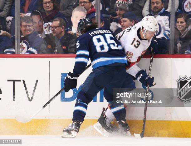 Mathieu Perreault of the Winnipeg Jets checks Mark Pysyk of the Florida Panthers along the boards during first period action at the Bell MTS Place on...
