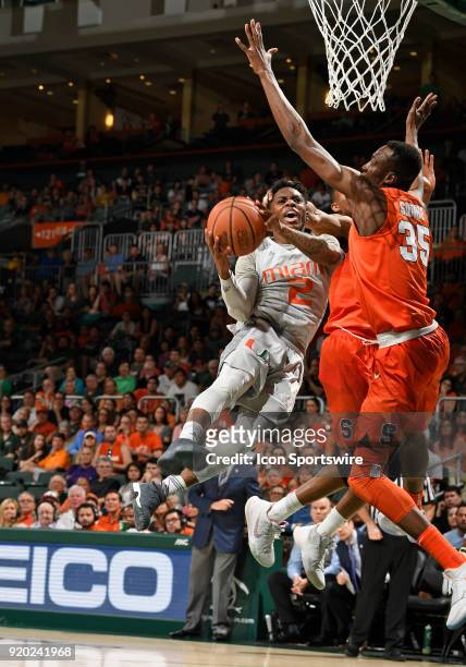 Miami guard Chris Lykes shoots against Syracuse forward Bourama Sidibe during a college basketball game between the Syracuse University Orange and...