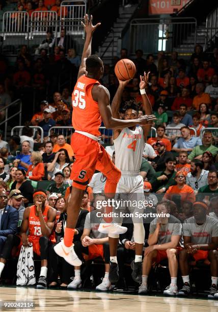 Miami guard Lonnie Walker IV shoots against Syracuse forward Bourama Sidibe during a college basketball game between the Syracuse University Orange...