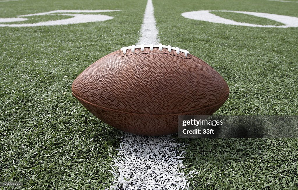 Ground level view of a football on the fifty yard line
